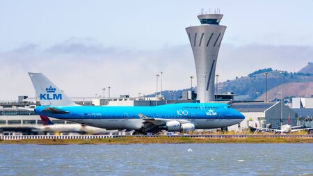 September 1, 2019 Burlingame / CA / USA - KLM aircraft preparing for take off at San Francisco International Airport (SFO); Traffic control tower visible in the backgroundのeditorial素材