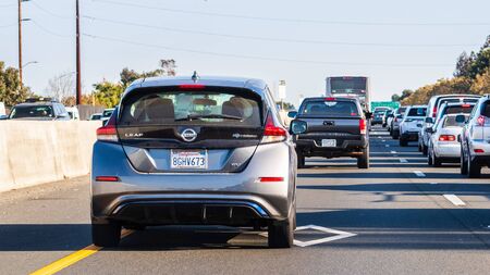 Oct 24, 2019 Mountain View / CA / USA - Back view of the new Nissan Leaf driving on the carpool lane on a busy freeway in Silicon Valley, South San Francisco Bay Areaのeditorial素材