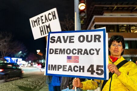 Dec 17, 2019 Mountain View / CA / USA - Protester carrying "Save our democracy / Impeach 45" placard at the Impeachment Eve Vigil rally held in one of the cities of San Francisco Bay;のeditorial素材