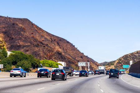 Dec 9, 2019 Los Angeles / CA / USA - Cars driving on Highway 405; Burned hills visible on the left...
