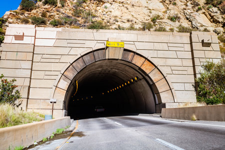 Tunnel carved into a mountain on Highway 1, California; maximum height displayed at the entrance;...