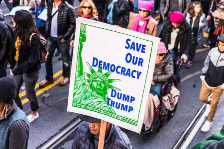 Jan 18, 2020 San Francisco / CA / USA - Participant to the Women's March event holds a sign asking for Trump's removal while marching on Market street in downtown San Franciscoのeditorial素材