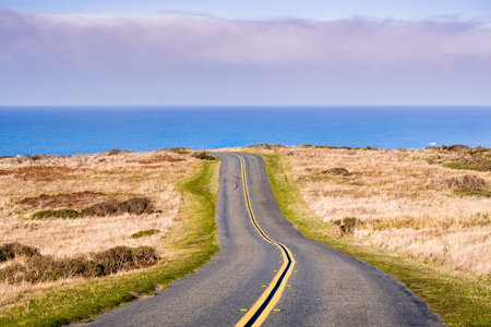 Winding road on the Pacific Ocean coastline on a clear sunny day, Point Reyes National Seashore,...