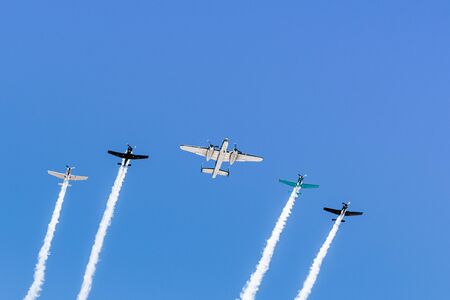 Historical airplanes flying in formation, leaving behind a white smoke trail; Californiaの写真素材