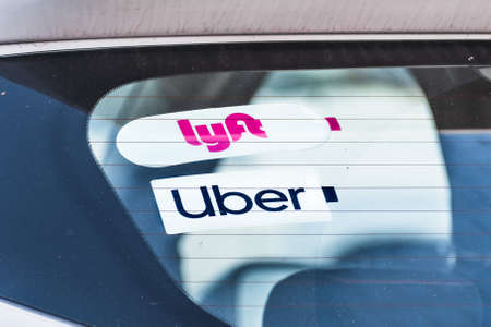 Dec 19, 2019 Redwood City / CA / USA - Lyft and UBER stickers on the rear window of a vehicle offering rides in San Francisco Bay Areaのeditorial素材