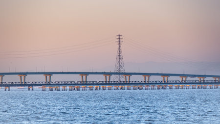 Sunset view of the raised part of Dumbarton Bridge and an old railroad track, connecting Fremont to...