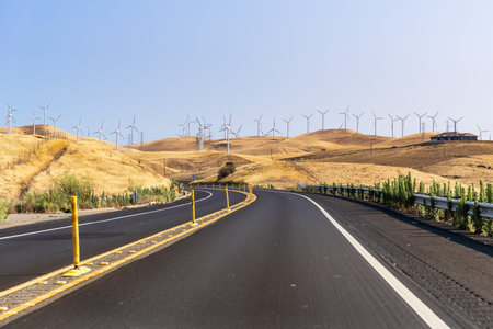 Highway crossing the hills and valleys of Alameda County close to Altamont Pass; Wind turbines...