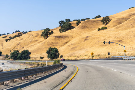 Freeway crossing the golden hills of Alameda County on a hot summer day; East San Francisco Bay...