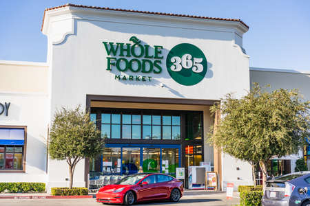 Oct 31, 2020 Concord / CA / USA - Whole Foods store located in East San Francisco Bay Area; Red Tesla Model 3 driving byのeditorial素材