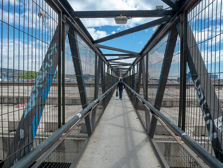 Man walks on metal bridgeの写真素材