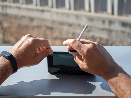 Person makes a photo with the smartphone with a cigarette.の写真素材