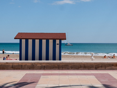 Beach atmosphere with beach bathers and sailing boat in the background.の写真素材