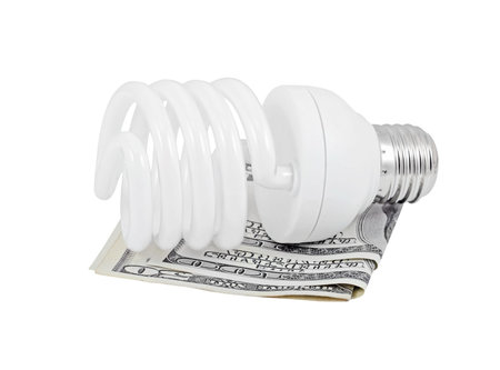 Energy saving light bulb and money, isolated on a white background