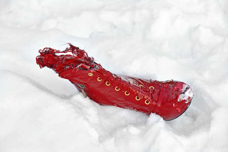 Lacerated red woman boot in fresh white snowの写真素材