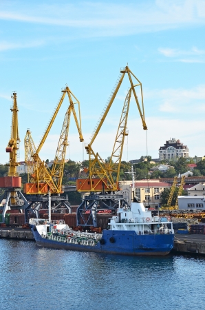 Bulk cargo ship under port crane bridge, Odessa, Ukraineの写真素材