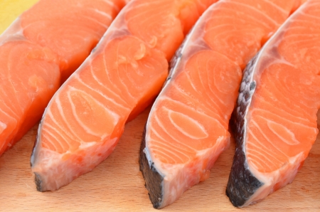 Fresh salmon steak slice on wooden background, DOFの写真素材