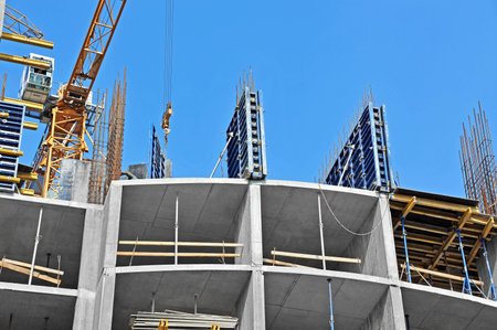 Crane and building construction site against blue sky