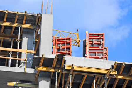 Crane and building construction site against blue sky