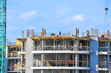 Crane and building construction site against blue sky