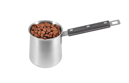 Coffee beans in steel cezve, isolated on a white backgroundの写真素材