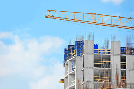 Crane and building construction site against blue sky