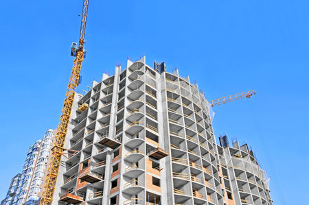 Crane and building construction site against blue sky