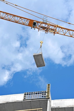 Crane and building construction site against blue skyの写真素材