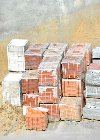 Stack of red clay brick on construction siteの写真素材
