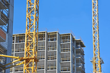 Crane and building construction site against blue sky
