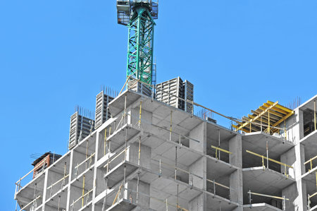 Crane and building construction site against blue sky