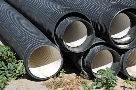 Stacked new PVC pipe on construction siteの写真素材