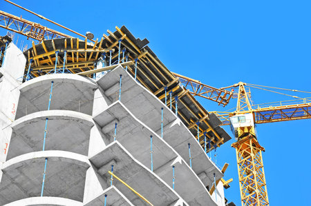 Crane and building construction site against blue sky