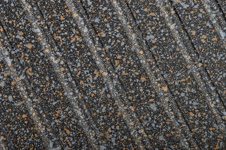 Black spotted textured  metallic background, close up