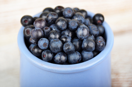 Blueberry in cup on vintage wooden backgroundの写真素材