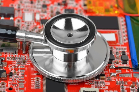 Printed computer motherboard and stethoscope, diagnostic service conceptの写真素材