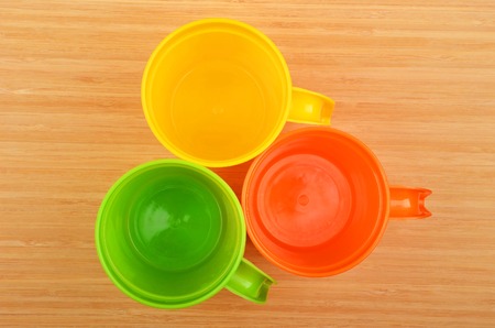 Set of color plastic mug on wooden backgroundの写真素材