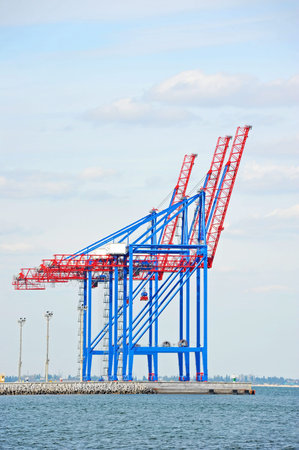 Port cargo crane over blue sky background
