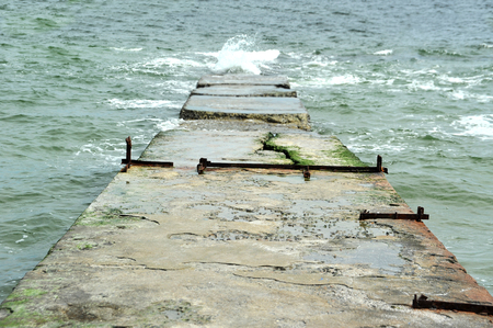 Wave of the sea and old concrete pierの写真素材
