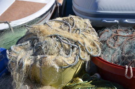 Old fishing net with buoy on pierの写真素材