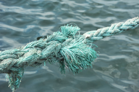 Old mooring rope over blue sea backgrondの写真素材
