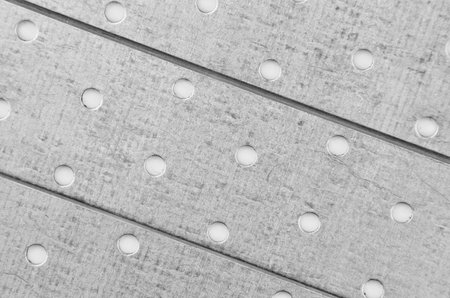 Perforated textured stell metallic background, close up