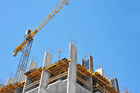 Crane and building under construction against blue sky