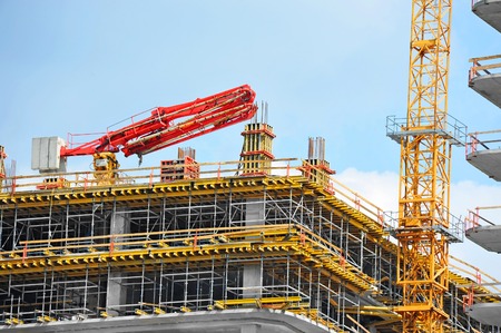 Crane and building under construction against blue skyの写真素材