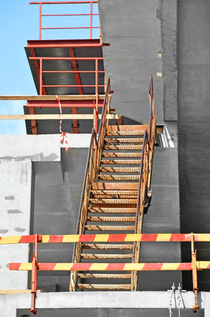 Metal ladder and wooden barrier on construction siteの写真素材