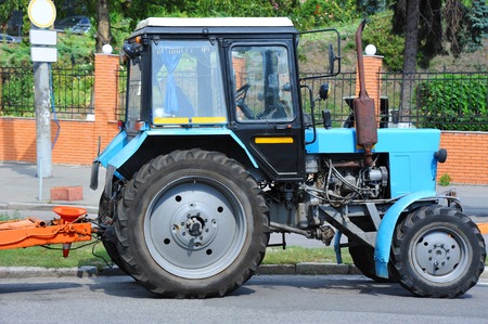 Blue tractor on road near construction siteの写真素材