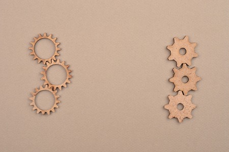 Vintage wooden gear on beige cardboard backgroundの写真素材