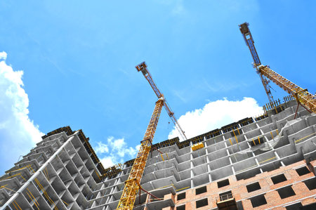 Crane and building under construction against blue sky
