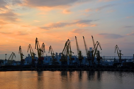 Port cargo crane over sunset sky backgroundの写真素材