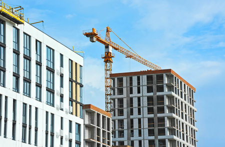Crane and building under construction against blue sky