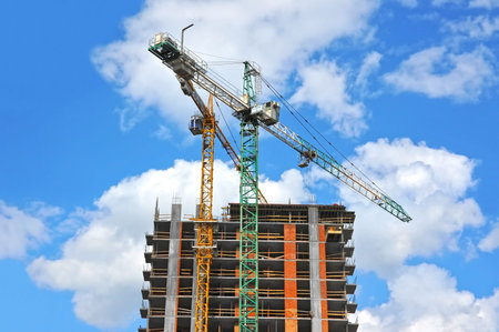 Crane and building under construction against blue sky